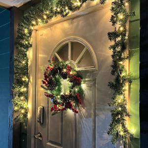 a door with a christmas wreath on it at Taeheung Art Theater Pension in Seogwipo