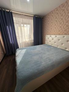 1 dormitorio con cama y ventana en 5 мин международный аэропорт en Prigorodnyy