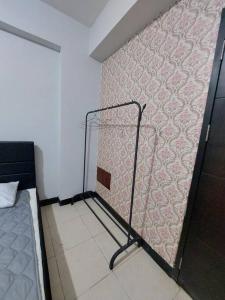 Habitación con una pared de color rosa y 1 cama en Apartemen Casablanca East Residence, en Yakarta