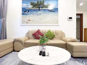 - un salon avec un canapé et une table dans l'établissement Luxury Apartment at Vinhomes Central, à Hô-Chi-Minh-Ville