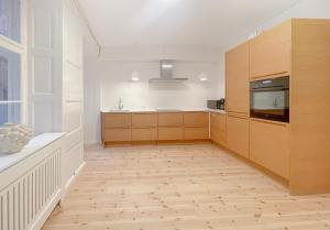 a kitchen with white walls and wooden cabinets at Homely Apartment by CPH Canals in Copenhagen