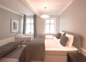 a bedroom with a large bed and two windows at Homely Apartment by CPH Canals in Copenhagen