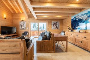 a living room with a couch and a table at Chalet du Tricot - Vue sur le Mont Blanc in Saint-Gervais-les-Bains