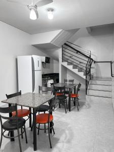 uma sala de jantar com mesas e cadeiras e uma escadaria em Spot Hotel e pousada em Uberlândia