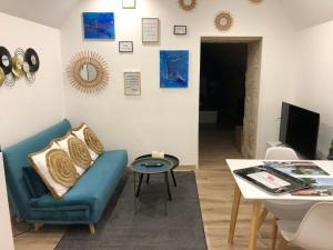 ein Wohnzimmer mit einem blauen Sofa und einem Tisch in der Unterkunft Trog'Love: Balnéo détente dans une troglodyte in Tours