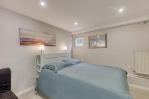 a white bedroom with a bed and a mirror at Studio cosy - 35m2 - Paris -Disneyland - Rer A in Noisy-le-Grand