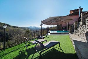 eine Terrasse mit einem Stuhl und einem Sonnenschirm neben einem Haus in der Unterkunft Baia di Campo in Campomorone