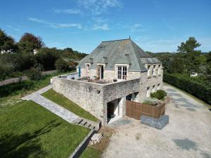 an external view of a stone house with a roof at Le Panoramique in Barneville-Carteret
