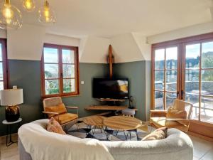 a living room with a couch and a tv at Le Panoramique in Barneville-Carteret