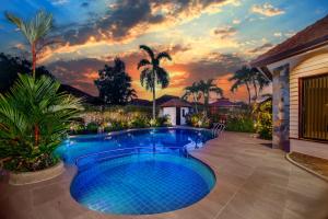 a swimming pool in a yard with a sunset at Pattaya Hill close to Walking St and City in Nong Prue