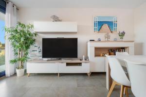 a living room with a television on a white cabinet at Cambrils Platja in Cambrils