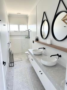 a bathroom with two sinks and a large mirror at Cute annexe - close to Manly Marina in Brisbane