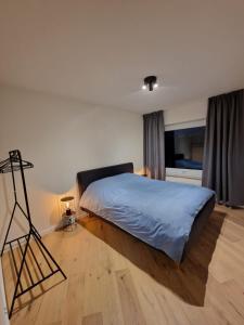 una camera da letto con un letto con una coperta blu sul pavimento di Luxury Renovated 3 Rooms Apartment a Ostenda