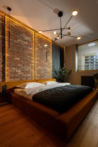Cama grande en habitación con pared de ladrillo en Brooklyn Studio - Aviatiei Park - Netflix - Parking, en Bucarest