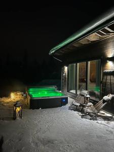 a pool in the snow next to a house at Silencius Cabin With Private Jacuzzi in Rovaniemi