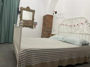 a white bed in a room with a mirror at Catania Centro Storico in Catania