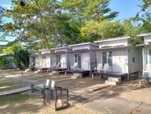 a row of houses with tables and chairs in front at Patoo in Ko Chang