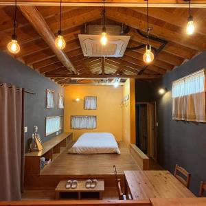 a bedroom with a bed and a table and lights at Taeheung Art Theater Pension in Seogwipo