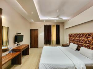 a hotel room with a bed and a television at The Kanila Resort in Karjat