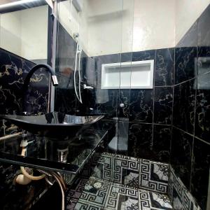 a bathroom with a sink and a black tiled wall at Residência Thomas in Itacaré +23 photos