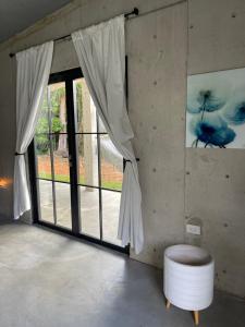 una stanza con una grande finestra e uno sgabello bianco di The Serene House Bed & Breakfast a Luquillo