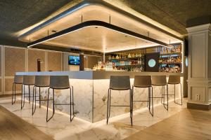 a bar with bar stools in a room at VP Madroño in Madrid