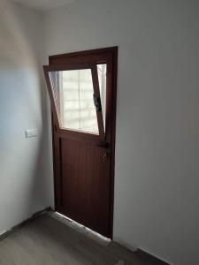 Una puerta de madera en una habitación con ventana en Motoroom, en Tijarafe