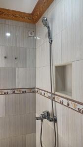 a shower with a shower head in a bathroom at Arsya Bagas Villa in Bogor