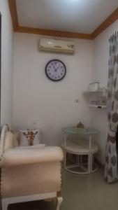 een kamer met een klok aan de muur en een tafel bij Arsya Bagas Villa in Bogor