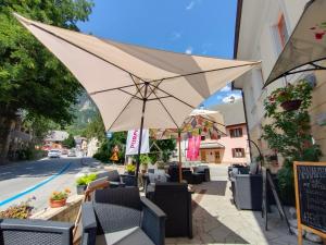 un parasol assis sur un trottoir à côté d'une rue dans l'établissement Garni Hotel Bovec, à Bovec