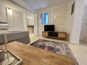 a living room with a bed and a flat screen tv at The blue house Athens in Athens