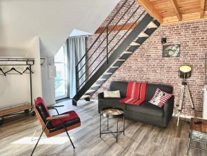 - un salon avec un canapé et un mur en briques dans l'établissement Le Patio de Loiseau, au Mans