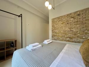 um quarto com uma cama e uma parede de tijolos em The blue house Athens em Atenas