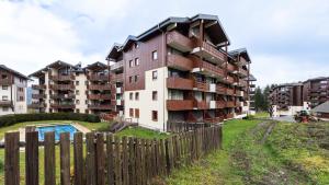 ein Apartmenthaus mit einem Zaun davor in der Unterkunft Les Eterlous 28 - Appt montagne 4 pers in Morillon