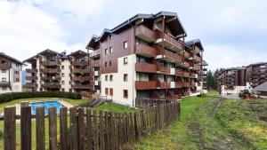 an apartment building with a fence in front of it at Les Eterlous 28 - Appt montagne 4 pers in Morillon
