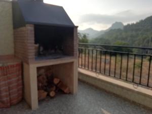 a fireplace on a balcony with a view at Casa Rural Puente Del Segura in Elche de la Sierra