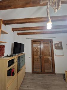 sala de estar con TV y puerta de madera en Appartamento isola rossa vista mare, en Isola Rossa