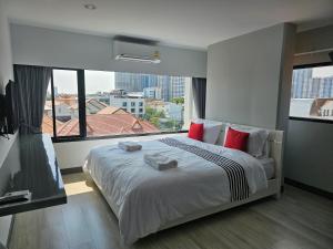 una camera da letto con un grande letto con una grande finestra di โรงแรมแอเรียเพลส สาทร (AREA Place) a Chong Nonsi