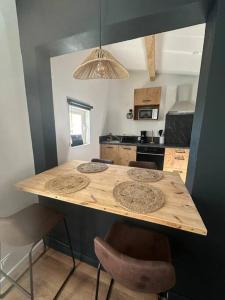 a kitchen with a wooden counter top with stools at Appartement Font-Romeu 2/4 pers. in Font-Romeu-Odeillo-Via