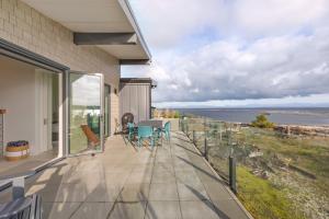 a balcony of a house with a table and chairs at Beachfront Luxury Suite #15 at THE BEACH HOUSE in Campbell River