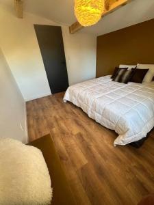 a bedroom with a bed and a wooden floor at Appartement Font-Romeu 2/4 pers. in Font-Romeu-Odeillo-Via