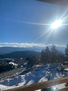 a snow covered hill with the sun in the sky at Appartement Font-Romeu 2/4 pers. in Font-Romeu-Odeillo-Via