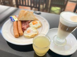 a plate of breakfast food and a drink on a table at Ratana Hill Patong in Patong Beach