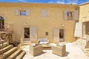 Una casa de ladrillo con dos sillas y un patio. en Authentique propriété, en Bonnieux