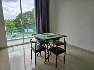un tavolo e due sedie in una stanza con finestra di Party House Corner Lot Bandar Sri Sendayan Seremban a Siliau