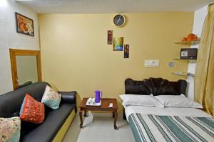 Zimmer mit 2 Betten, einem Sofa und einem Tisch in der Unterkunft Coral Home Stay in Puducherry