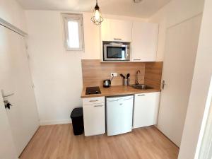 a small kitchen with a sink and a microwave at Superbe 2 pièces rénové et calme in Aubervilliers