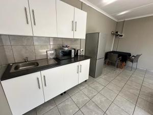 uma cozinha com um lavatório e um frigorífico em 15 On Natorp em Polokwane