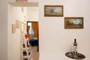 ein Zimmer mit Gemälden an der Wand und einem Regal in der Unterkunft Briogna by Maravigghia Palermo in Palermo