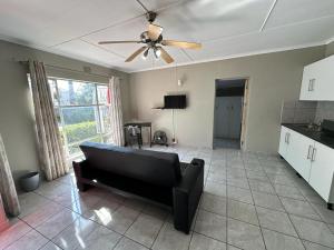 a living room with a couch and a ceiling fan at 15 On Natorp in Polokwane
